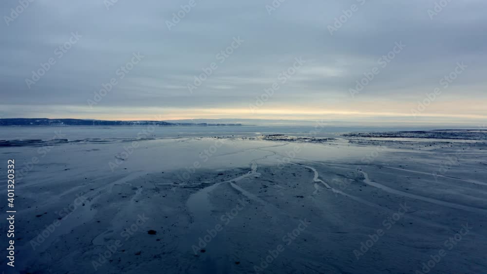 Aerial shot over the water of the shore of a beach in winter in Charlevoix Aerial shot over the water of the shore of a beach in winter in Charlevoix