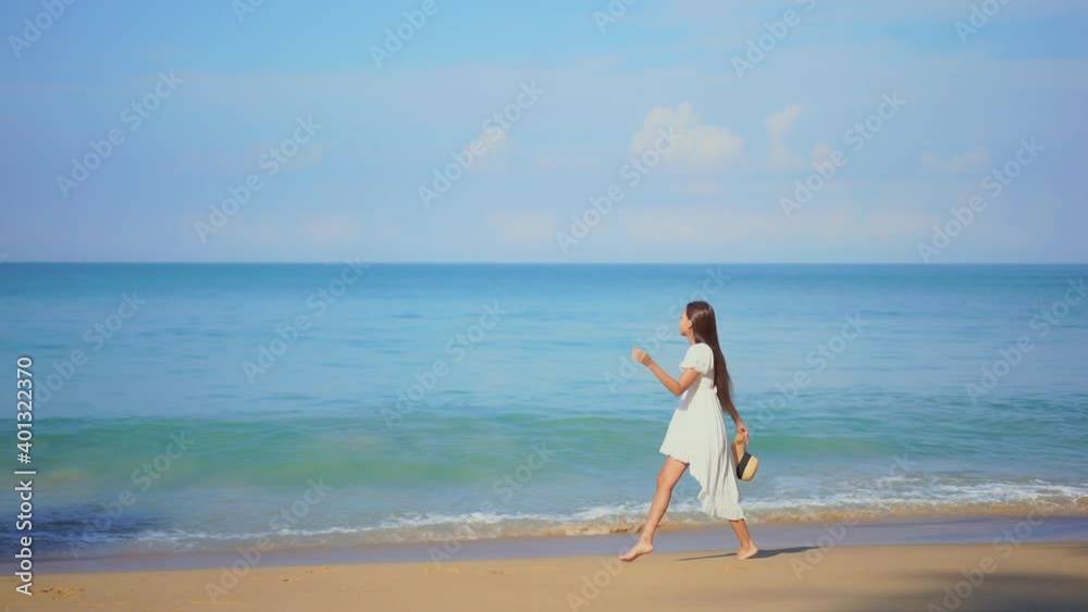 Beautiful girl walks on seashore dressed in white. Slow-motion Beautiful girl walks on seashore dressed in white. Slow-motion