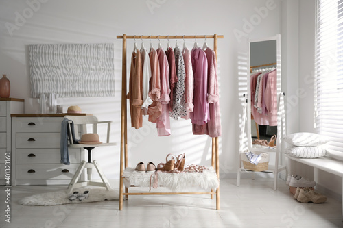 Rack with stylish women's clothes indoors. Interior design © New Africa