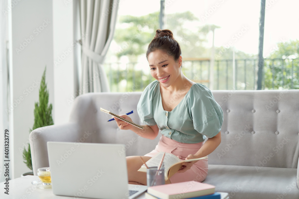 young woman browse internet noting something relaxing on sofa young woman browse internet noting something relaxing on sofa