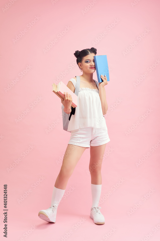 Portrait of student girl with backpack and books on pink background Portrait of student girl with backpack and books on pink background