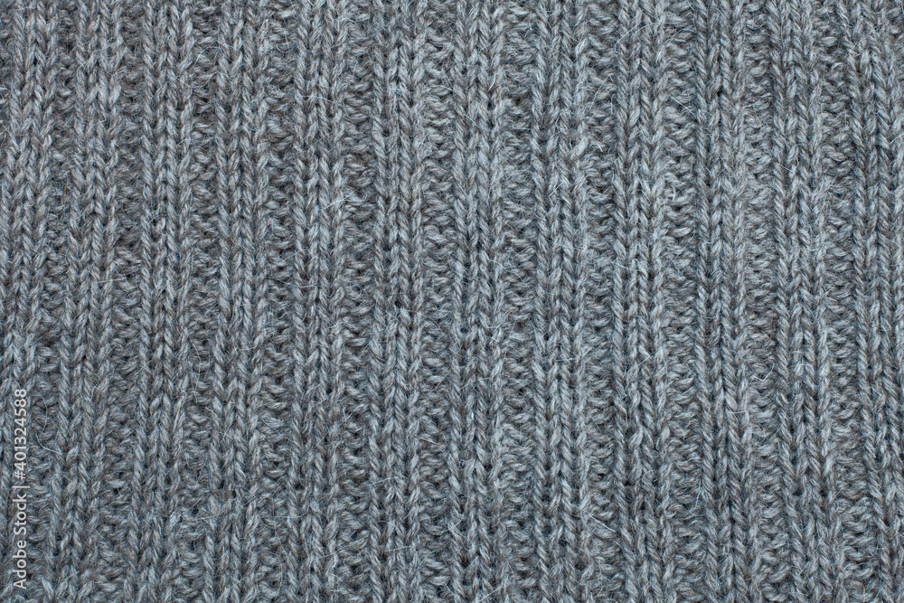 Gray knitted canvas, natural wool, tricot, hand knit, elastic, ribs, clouseup Gray knitted canvas, natural wool, tricot, hand knit, elastic, ribs, clouseup