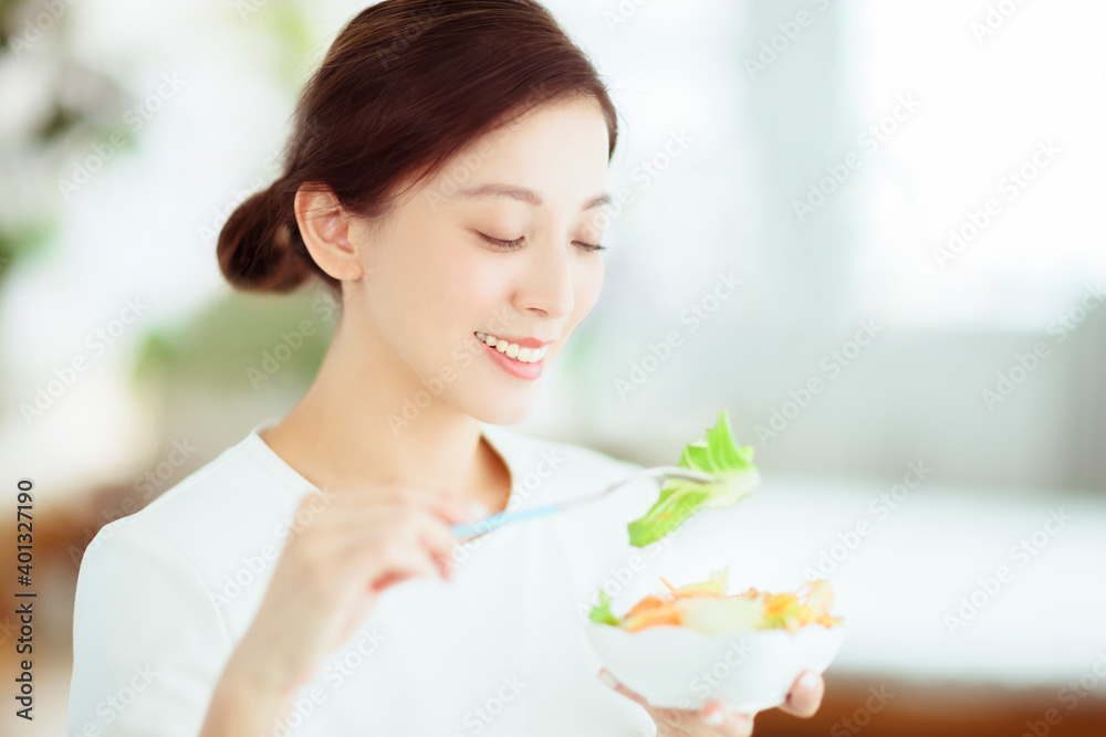 Young happy woman eating healthy salad at home Young happy woman eating healthy salad at home