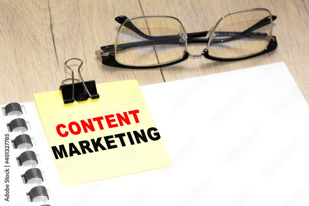 Text CONTENT MARKETING on a notepad with eyeglasses and text documents. Could be for business, financial and marketing concepts Text CONTENT MARKETING on a notepad with eyeglasses and text documents. Could be for business, financial and marketing concepts