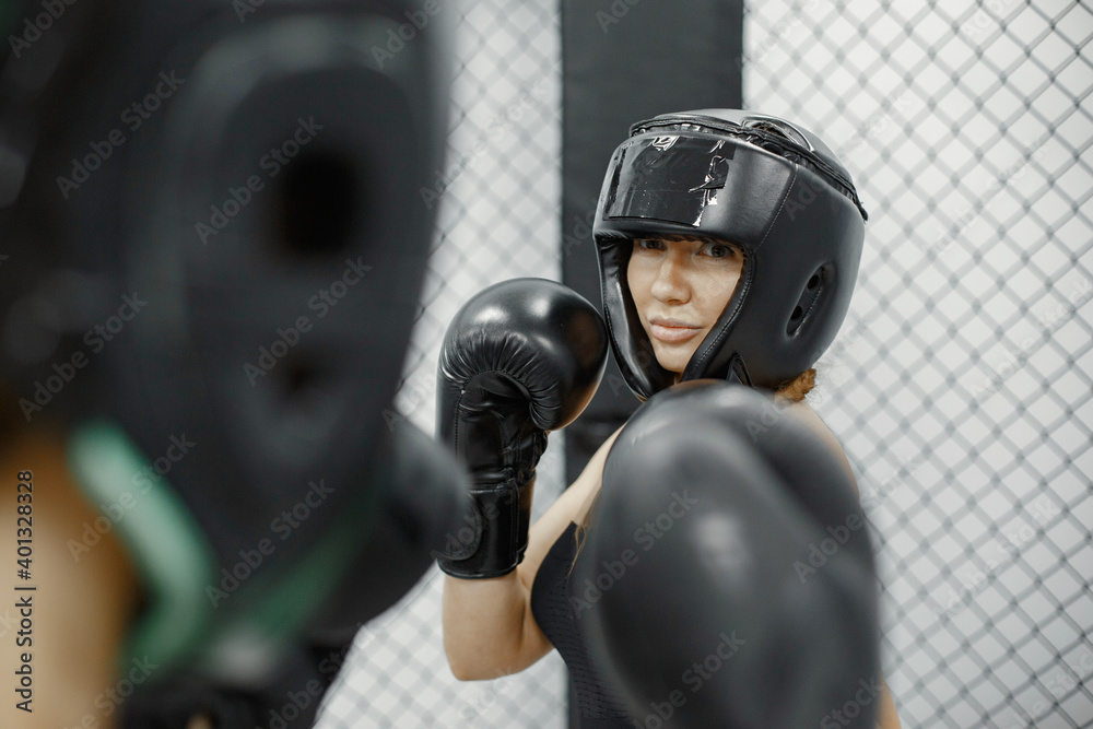 Women boxing. Beginners in a gym. Lady in a black sportwear.