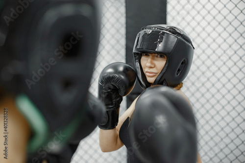 Women boxing. Beginners in a gym. Lady in a black sportwear.