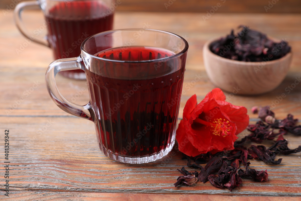 Delicious hibiscus tea and dry flowers on wooden table Delicious hibiscus tea and dry flowers on wooden table