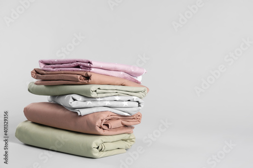 Canvas Print Stack of clean bed sheets on white background. Space for text