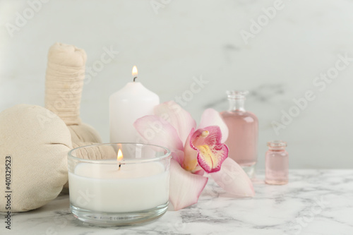 Beautiful spa composition with candles and aroma oil on white marble table