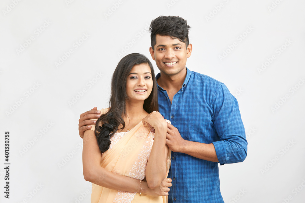 Cheerful Indian young couple in traditional outfit against white. Cheerful Indian young couple in traditional outfit against white.