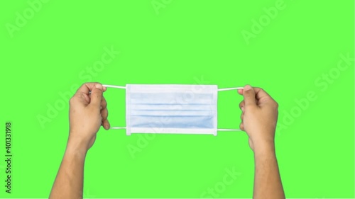 Man showing respiratory face mask holding equipment in his hands protected.Green screen. Close up.