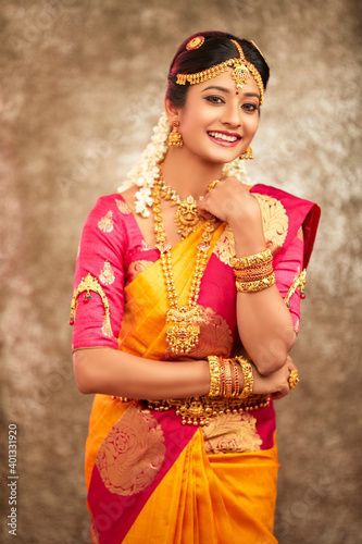 Photography Beautiful smiling Indian bride with jewelry in studio shot.