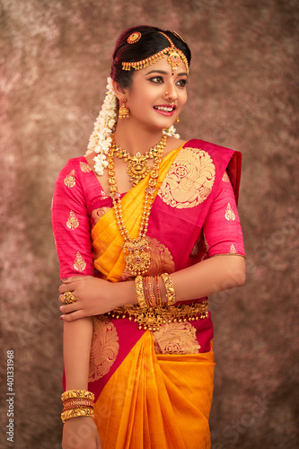 Beautiful smiling Indian bride with jewelry in studio shot.
