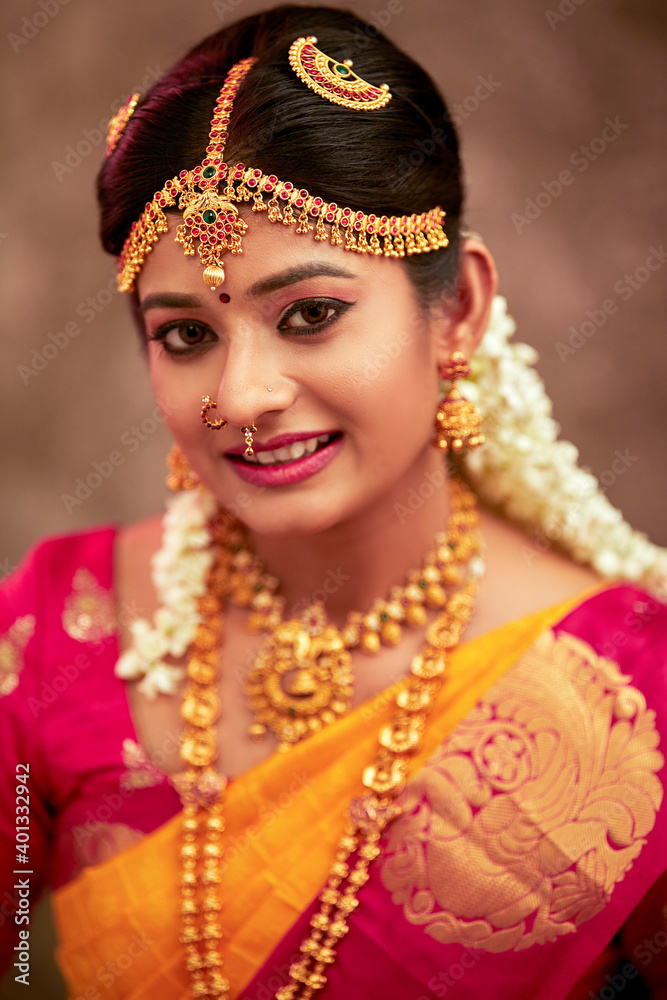 Beautiful smiling Indian bride with jewelry in studio shot.
