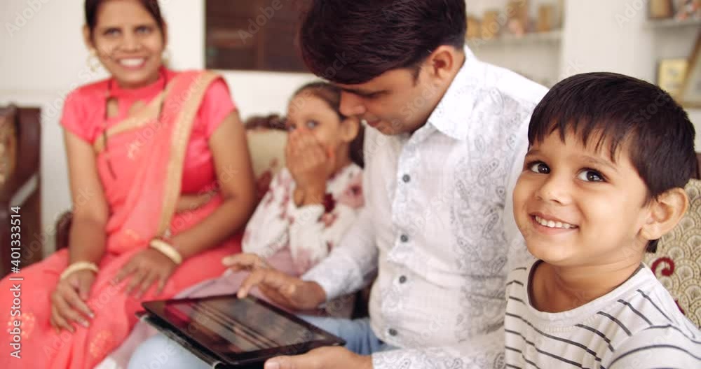 Slow-motion of parents, husband and wife, busy working from home using laptop computer digital technology touchscreen device device while the kids are playing with balloons smiling enjoying Slow-motion of parents, husband and wife, busy working from home using laptop computer digital technology touchscreen device device while the kids are playing with balloons smiling enjoying