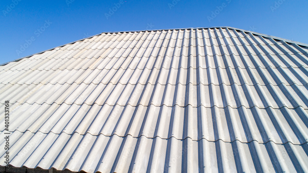 Modern roof. Roof covering. Roman profile. The roof of the house is covered with wavy gray tiles. Modern roof. Roof covering. Roman profile. The roof of the house is covered with wavy gray tiles.