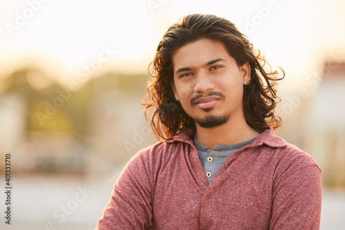 Handsome young man with long hair with evening back light.