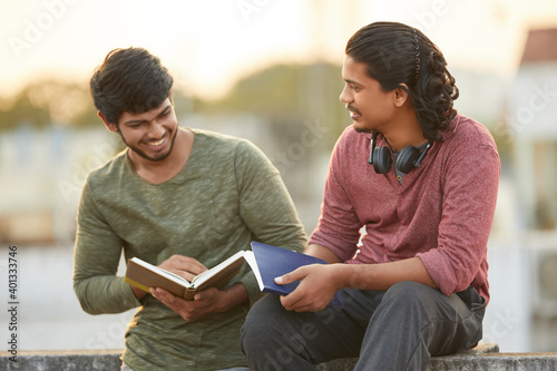 Photography Happy young people chatting with book on terrace.