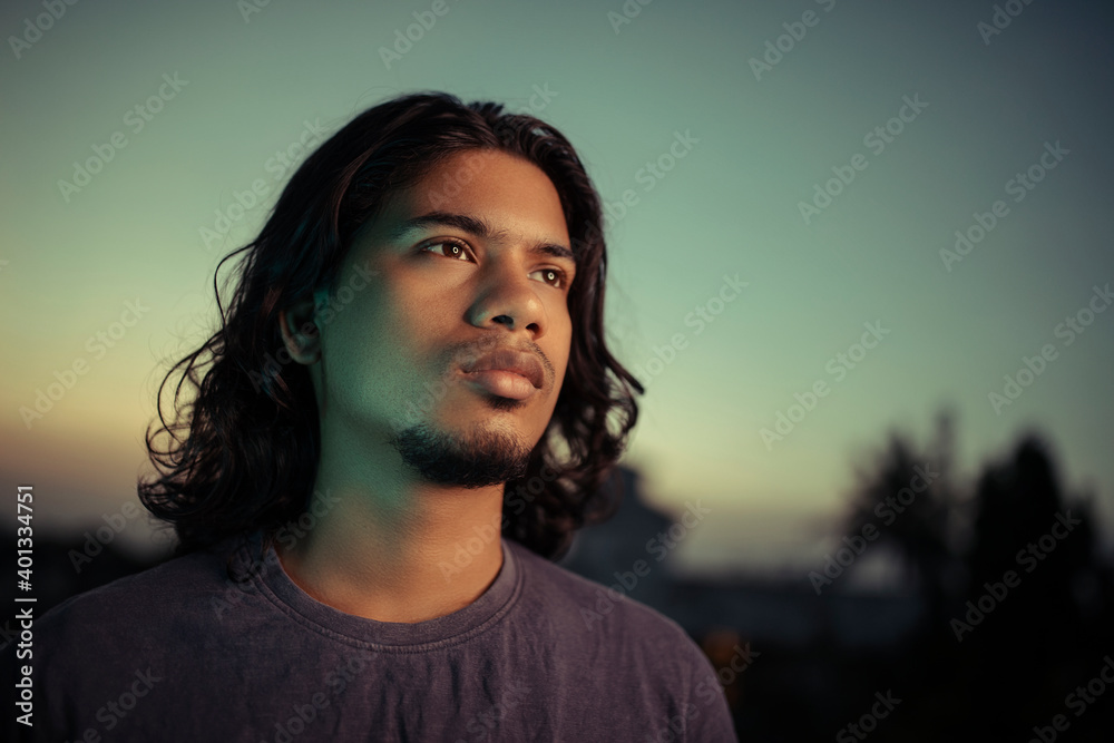 Young man portrait with long hair in evening light Young man portrait with long hair in evening light