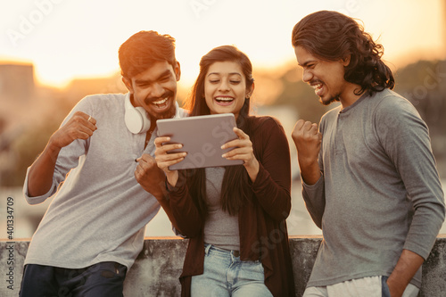 Excited of friends watching tv from tablet at outdoor background. photo