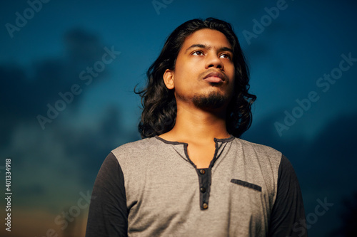 Canvas Print Young man portrait with long hair in evening light