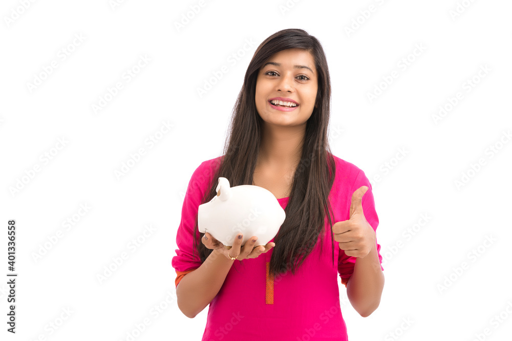 Cheerful young Woman Saves Money in Piggy bank on white background. Cheerful young Woman Saves Money in Piggy bank on white background.