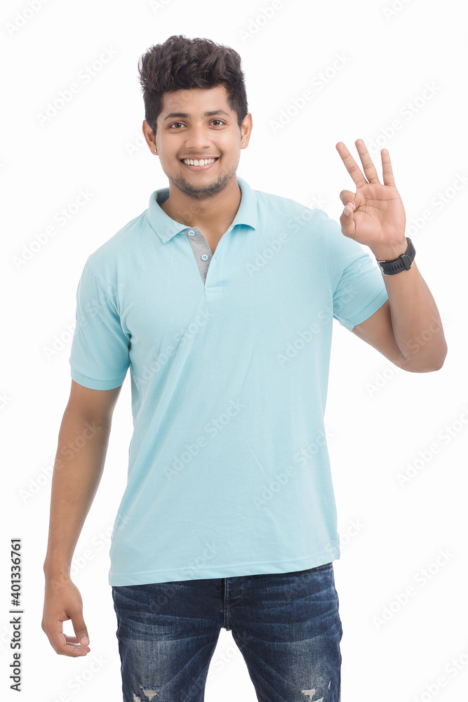 Fototapeta premium Happy Indian young man making super ok gesture isolated on white.