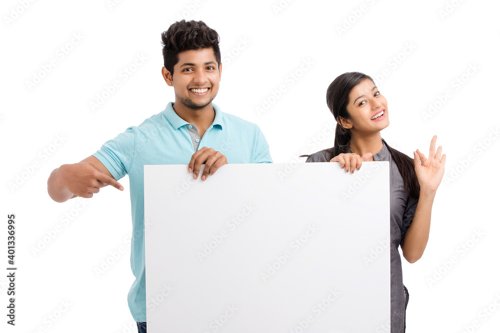 Cheerful cute young couples holding white board isolated on white. Cheerful cute young couples holding white board isolated on white.