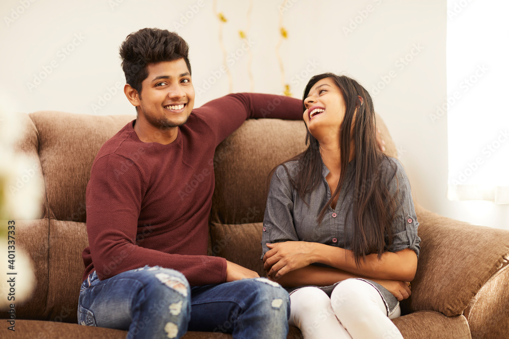 Young beautiful couple chatting on sofa at home