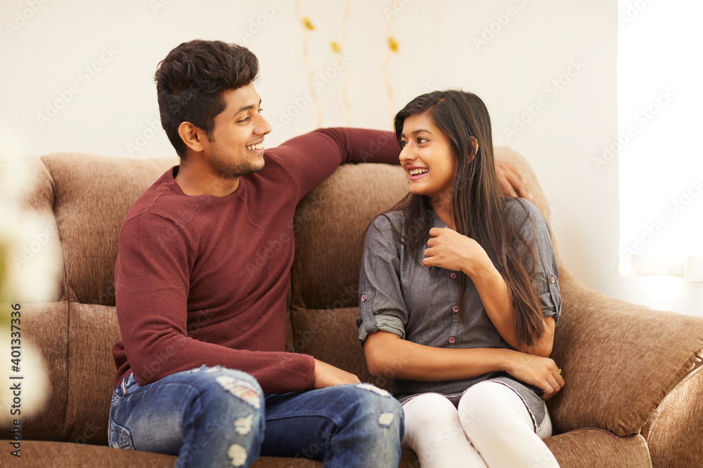 Young beautiful couple chatting on sofa at home Young beautiful couple chatting on sofa at home