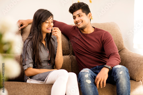 Young beautiful couple chatting on sofa at home