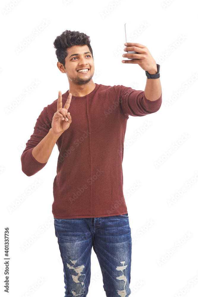 Attractive Indian young man taking selfie in mobile phone on white. Attractive Indian young man taking selfie in mobile phone on white.