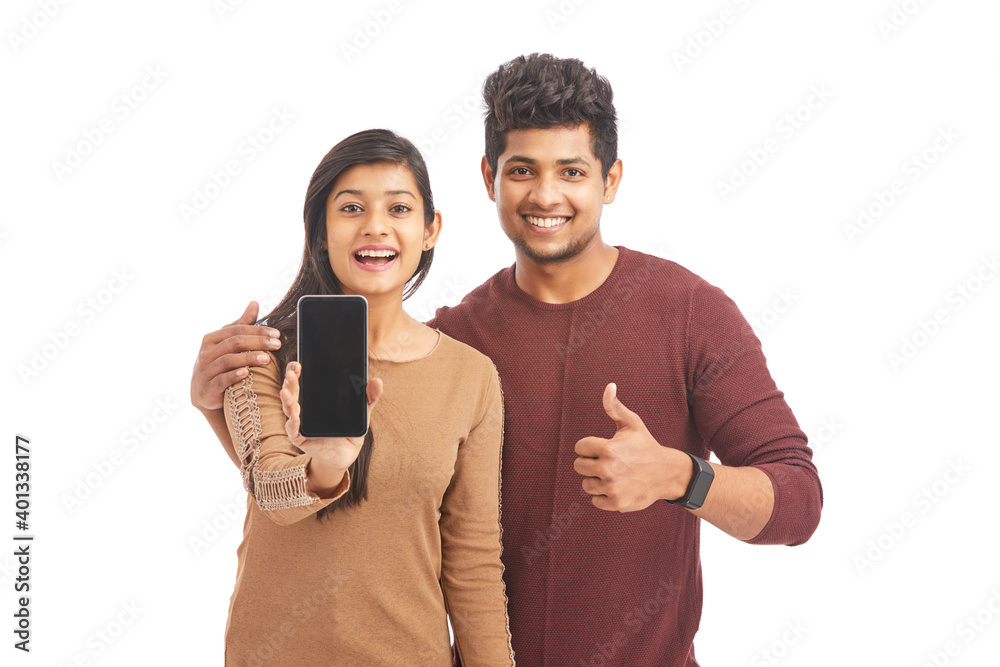 Beautiful happy young couple holding smart phone on white.