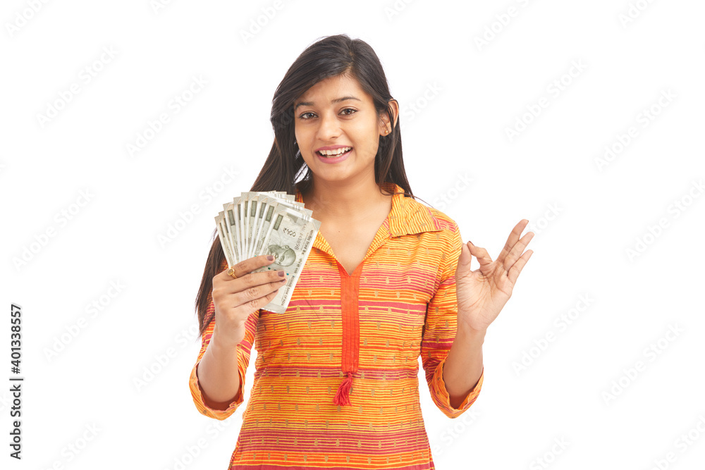 Young happy woman holding 500 rupee notes against white background Young happy woman holding 500 rupee notes against white background