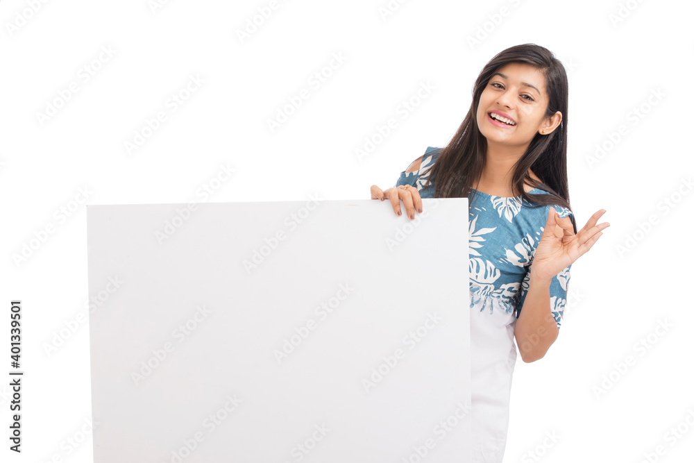 Cheerful attractive young women holding white board on white background. Cheerful attractive young women holding white board on white background.