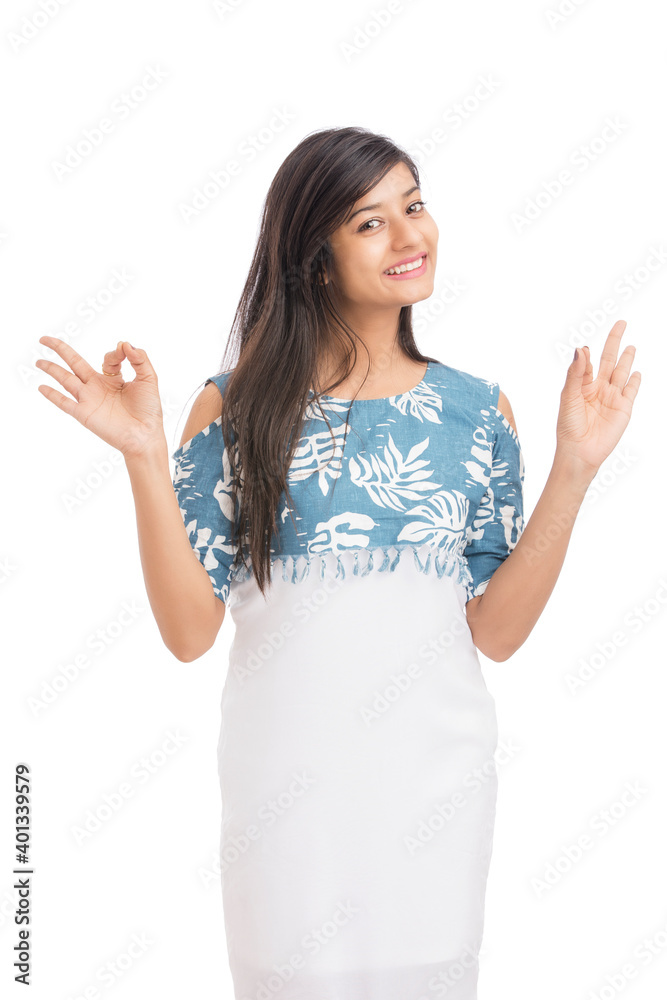 Happy young woman showing OK gesture against a white background Happy young woman showing OK gesture against a white background