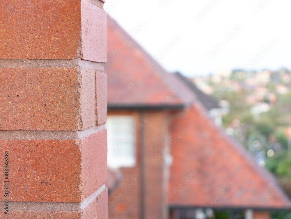 Naklejka premium Brick close up with houses in blurred background