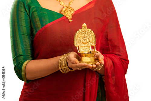 Hindu Indian young women holding Deepam in hands studio shot. ( Kamatchi vilakku ) photo