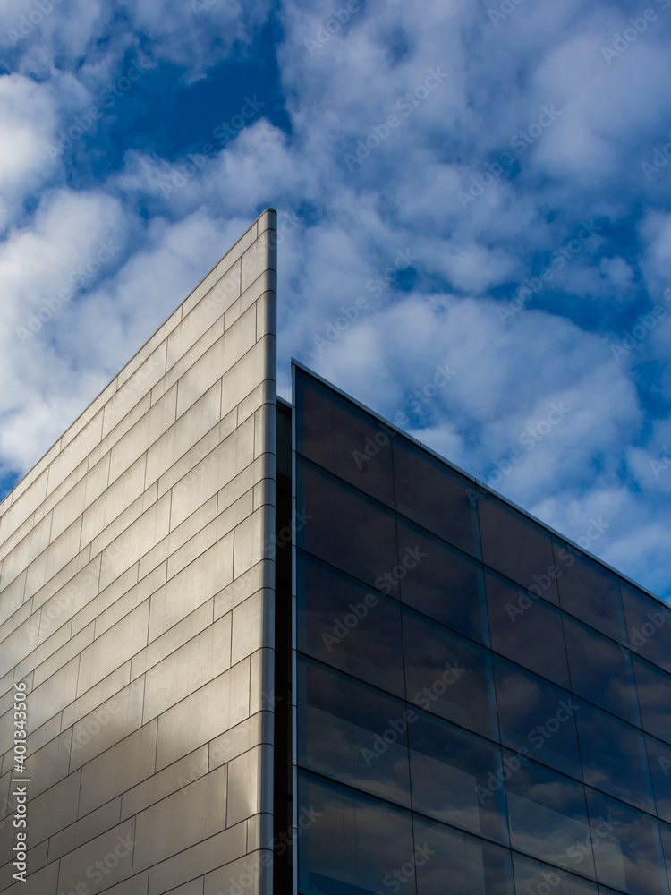 Modern building detail with reflection of cloudy sky