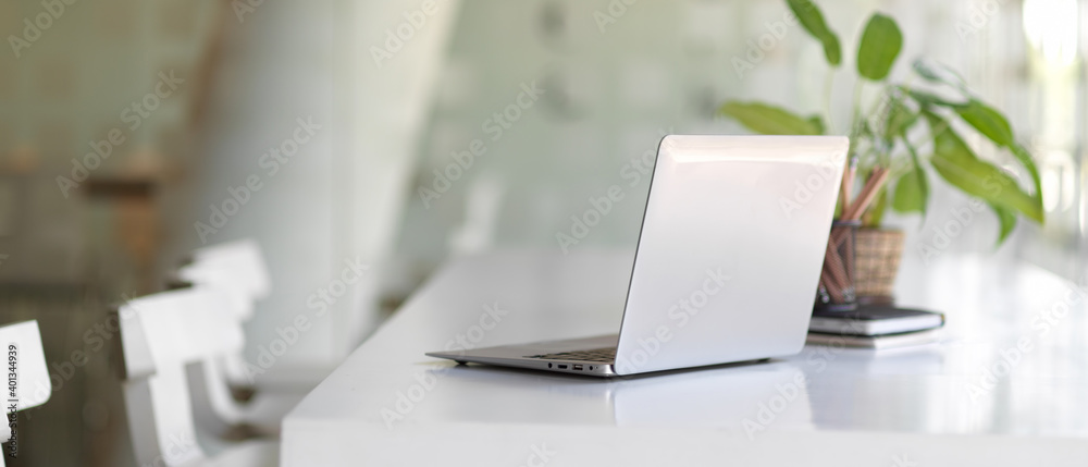 Portable workspace with laptop, plant pot and stationery in co-working space Portable workspace with laptop, plant pot and stationery in co-working space