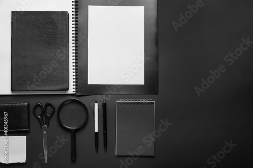 Composition with blank paper sheet and stationary on dark background