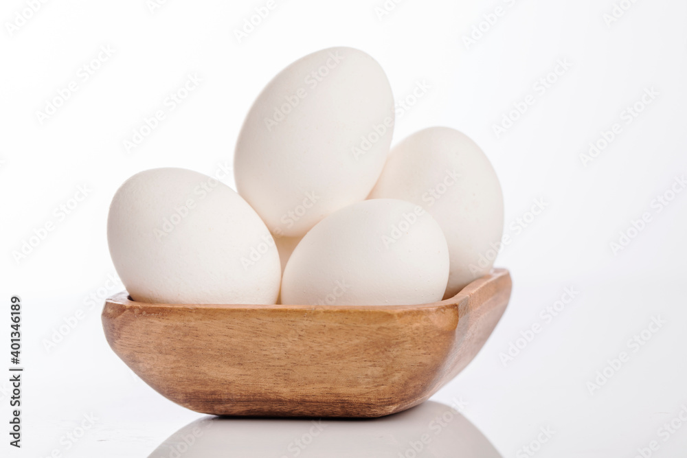 Wooden cup of white eggs on white background. Wooden cup of white eggs on white background.