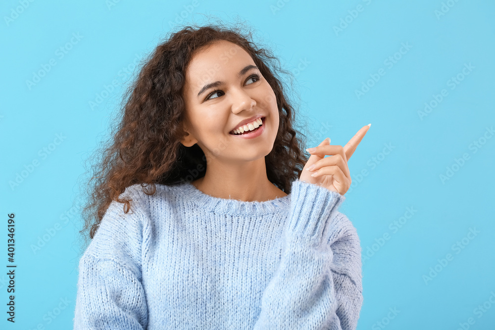 Beautiful young woman showing something on color background Beautiful young woman showing something on color background