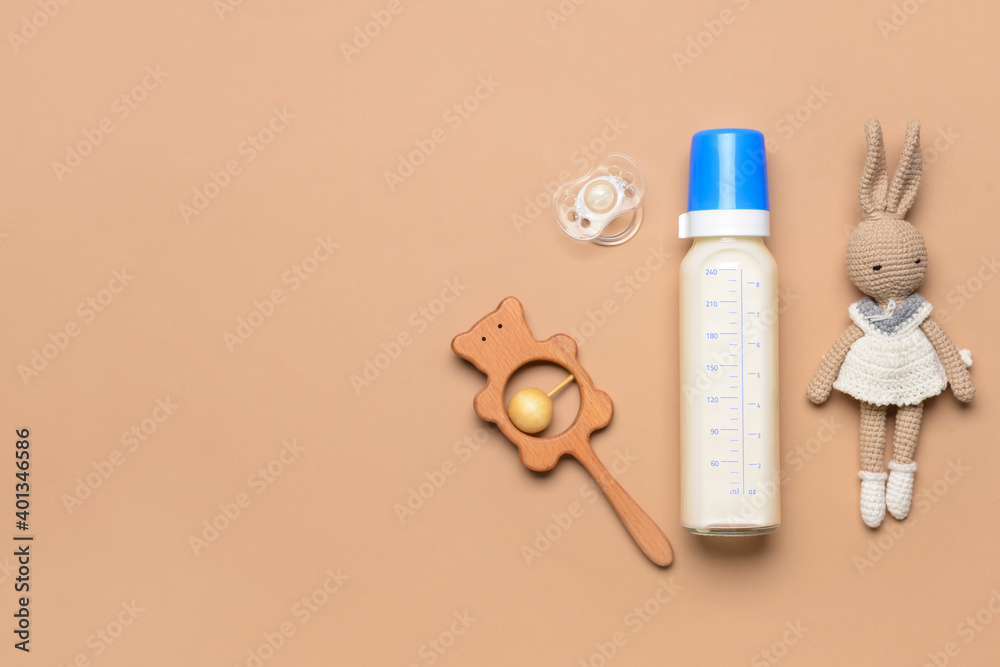 bottle-of-milk-for-baby-and-accessories-on-color-background-stock-photo