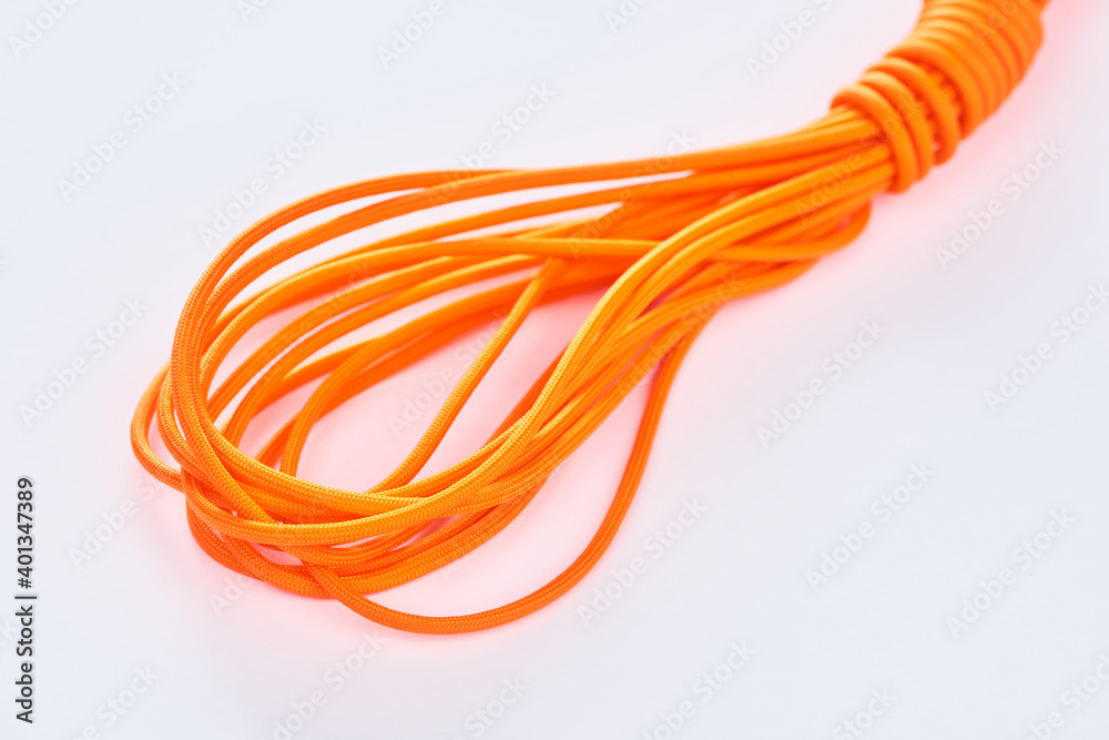 Close-up on a coil of orange nylon cord on white background Close-up on a coil of orange nylon cord on white background