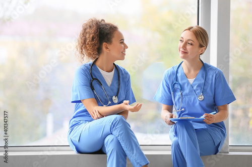 Female doctors sitting on w...