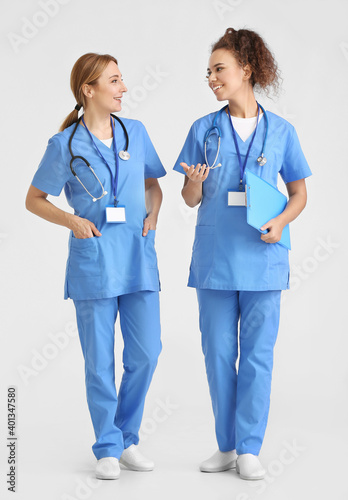 Portrait of female doctors on light background
