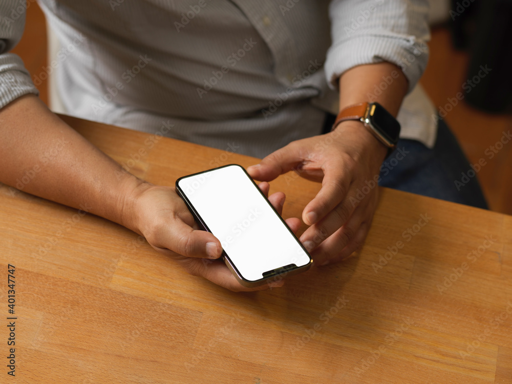 Close up view of male hands using smartphone on wooden desk Close up view of male hands using smartphone on wooden desk