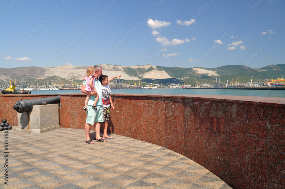 Dad, daughter and son walk along the embankment of Novorossiysk