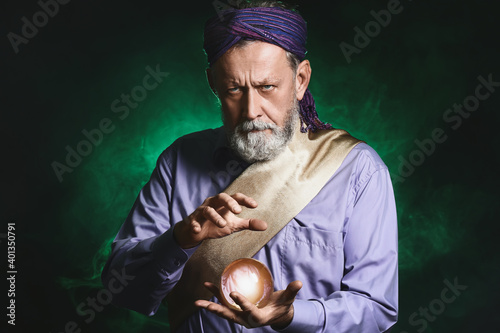 Φωτογραφία Male fortune teller with crystal ball on dark background